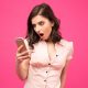 Shocked woman looking at her phone